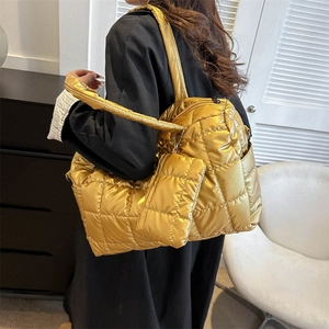 Détail du grand sac cabas matelassé doré avec une pochette assortie au fini brillant