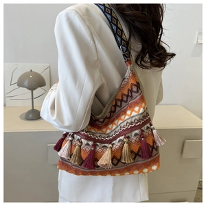 Dettaglio di borsa boho tessuta con motivi geometrici colorati e frange decorative