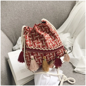 Dettaglio borsa a secchiello in tweed con frange colorate e tracolla in corda bianca