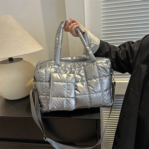 Détail du sac à main matelassé argenté avec finition métallisée et petite pochette assortie