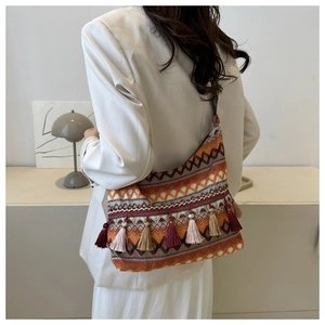 Dettaglio borsa tote bohémien con motivi intrecciati e lunghe nappe colorate vivaci