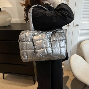 Détail d'un grand cabas argenté matelassé avec une pochette zippée assortie au style moderne