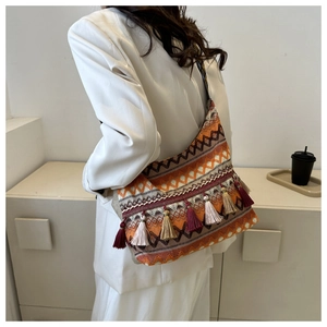 Dettaglio della borsa boho a tracolla con nappe colorate e motivo geometrico intrecciato