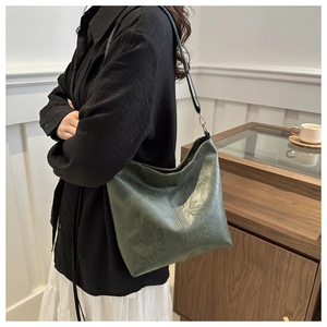 Detailed close-up of dark green hobo bag featuring vintage oil leather texture and stitching