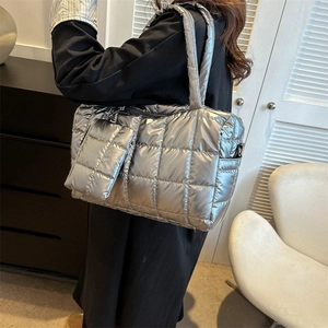 Gros plan sur le cabas matelassé argenté avec une petite pochette détachable assortie