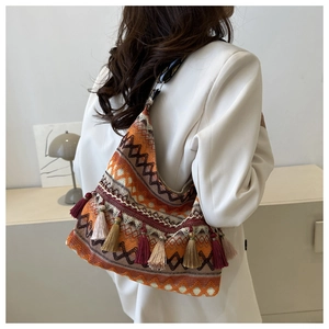 Dettaglio borsa bohémien con motivi geometrici tessuti e frange lunghe