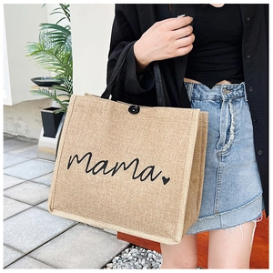Detail of jute tote bag with Mama print, black handles, and button closure