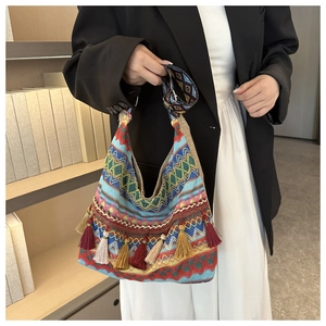 Dettaglio della borsa tote in maglia bohémien con nappe colorate e motivi tessuti