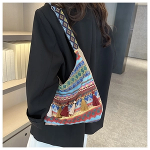 Dettaglio borsa tote boho tessuta con nappe colorate e tracolla a motivi geometrici