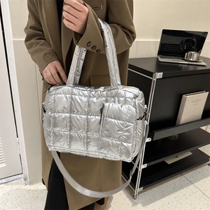 Détail du sac fourre-tout argenté matelassé avec surpiqûres carrées et pochette