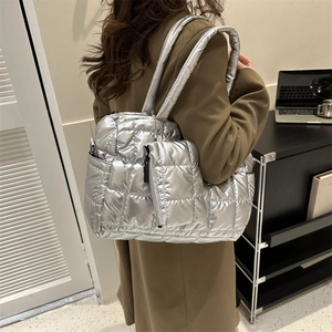 Détail d'un sac cabas matelassé argenté avec mini pochette et larges bandoulières