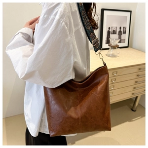 Close-up of brown PU leather tote with an ethnic style embroidered wide strap