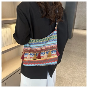 Dettaglio ravvicinato della borsa tote boho tessuta con nappe colorate e motivi a onde