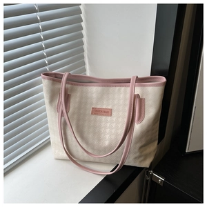 Dettaglio della borsa tote pied de poule con finiture in pelle rosa e logo goffrato