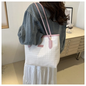 Dettaglio della borsa tote pied de poule bianca con finiture in pelle rosa ed etichetta