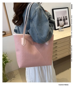 Détail du sac cabas rose tissé montrant la texture tressée et la fine bandoulière