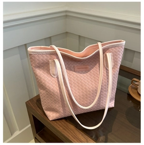 Détail du cabas en cuir tressé rose avec un écusson logo Fashion & Bags en cuir ton sur ton