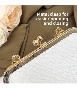 Detail of vintage gold hardware clasp on white woven clutch with floral background