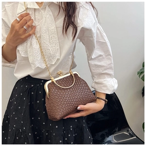Detail of vintage brown woven crossbody bag with gold metal frame and ball clasp closure