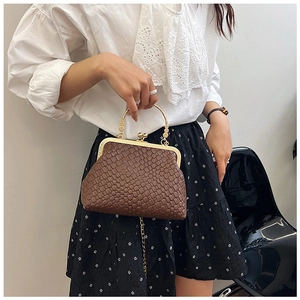 Detail of vintage woven shell bag with elegant gold metal handle and clasp closure