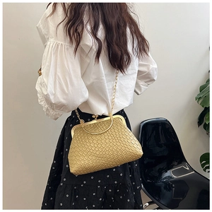 Rear view of a model styling a yellow crocodile texture shell bag with a metal handle