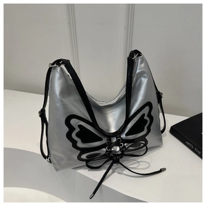 Détail du sac hobo argenté métallisé avec grand patch papillon noir et ruban