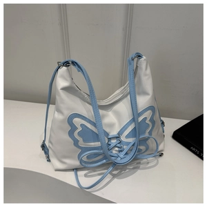 Détail du sac à bandoulière en PU blanc avec patch papillon bleu clair et lacets décoratifs