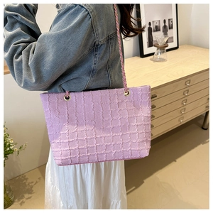 Detail of lavender tote bag with textured ruched pattern and gold chain strap