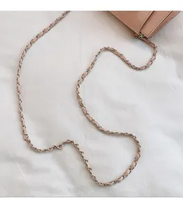 Detail eines hellrosa Lederriemens mit geflochtener silberner Metallkette für Umhängetaschen