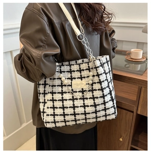 Detail of checkered tweed tote bag with pearl chain decoration and white leather strap