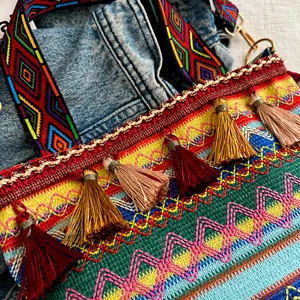 Dettaglio della borsa etnica a tracolla con ricami geometrici e nappe colorate