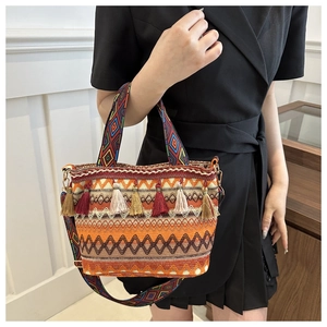 Dettaglio della borsa tessuta boho con motivi etnici e nappine multicolori
