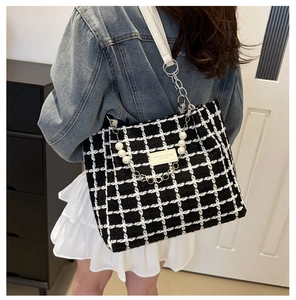 Detail of checkered tweed tote bag featuring white pearl and silver chain strap decoration