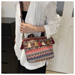 Dettaglio della borsa a tracolla boho intrecciata con motivi a onde e nappe colorate