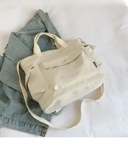 Close-up of a cream-white tote bag with FASHION label on a blue denim jacket background