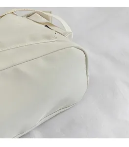 Macro detail of beige canvas tote bag with reinforced stitching and soft fabric texture