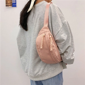 Riñonera de lona rosa con correa ajustable y cremallera decorativa mostrada en modelo