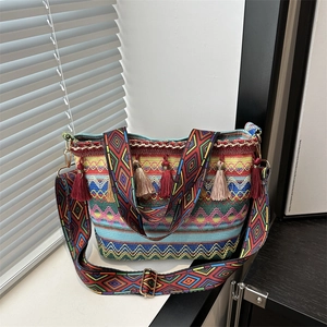 Borsa a tracolla intrecciata in stile etnico con motivi geometrici e nappe a frangia