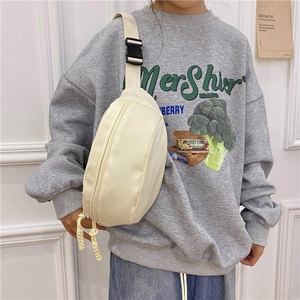 Detalle de bolso bandolera de lona beige claro en forma de media luna con correa ajustable