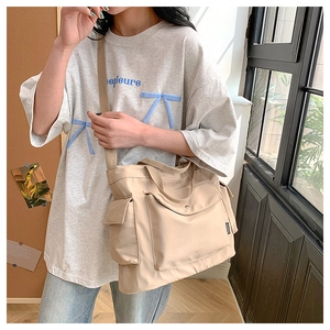 Gros plan du sac fourre-tout en toile beige avec étiquette mode et grande poche frontale