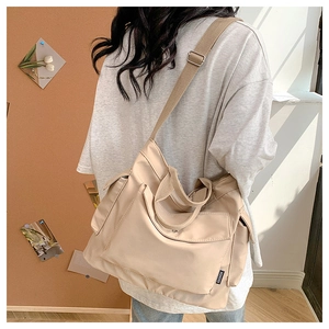 Detail of beige large capacity canvas tote with side pocket and adjustable wide strap