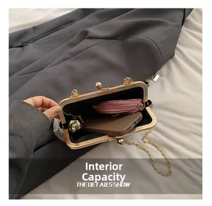 Dettaglio dell'interno della borsa bianca testurizzata con telefono e chiusura dorata