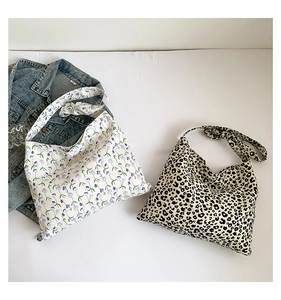 Detail of floral and leopard print canvas tote bags with stylish knot handle design
