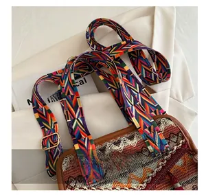 Dettaglio borsa a secchiello boho con ampia tracolla intrecciata a motivi geometrici