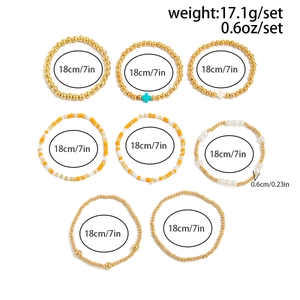 Détail du lot de 8 bracelets en perles dorées, perles d'imitation et pendentifs croix