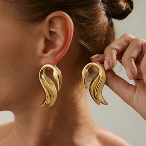 Nahaufnahme der eleganten goldenen Schwanenohrstecker mit hochglanzpoliertem Finish