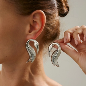 Detailansicht großer silberner Schwanen-Ohrringe mit poliertem Metallic-Spiegeleffekt