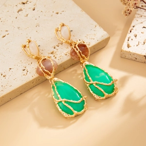 Detailaufnahme von Vintage Gold-Ohrringen mit grünen Harz-Anhängern in Tropfenform