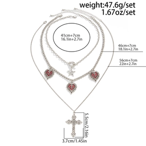 Dettaglio della collana gotica a tre strati con croce, stelle argentate e ciondoli a cuore