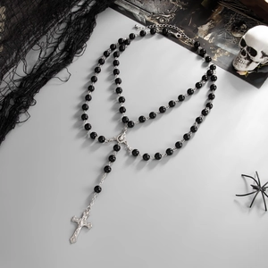 Double-layer gothic rosary necklace with black beads and silver cross over dark props